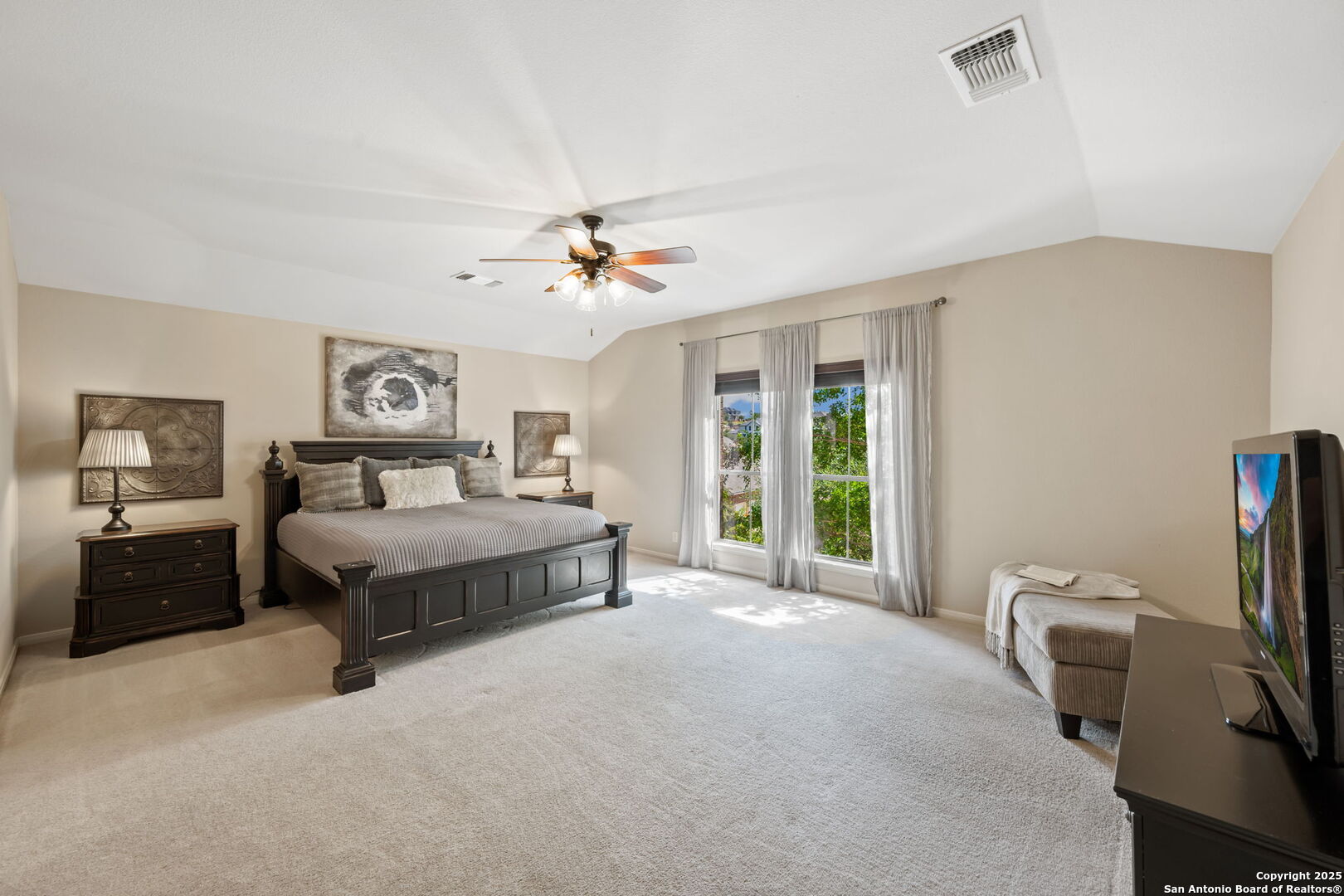 14507 John David Helotes, TX 78023 - Photo 12 of 49 a spacious bedroom with a bed a couch and a window