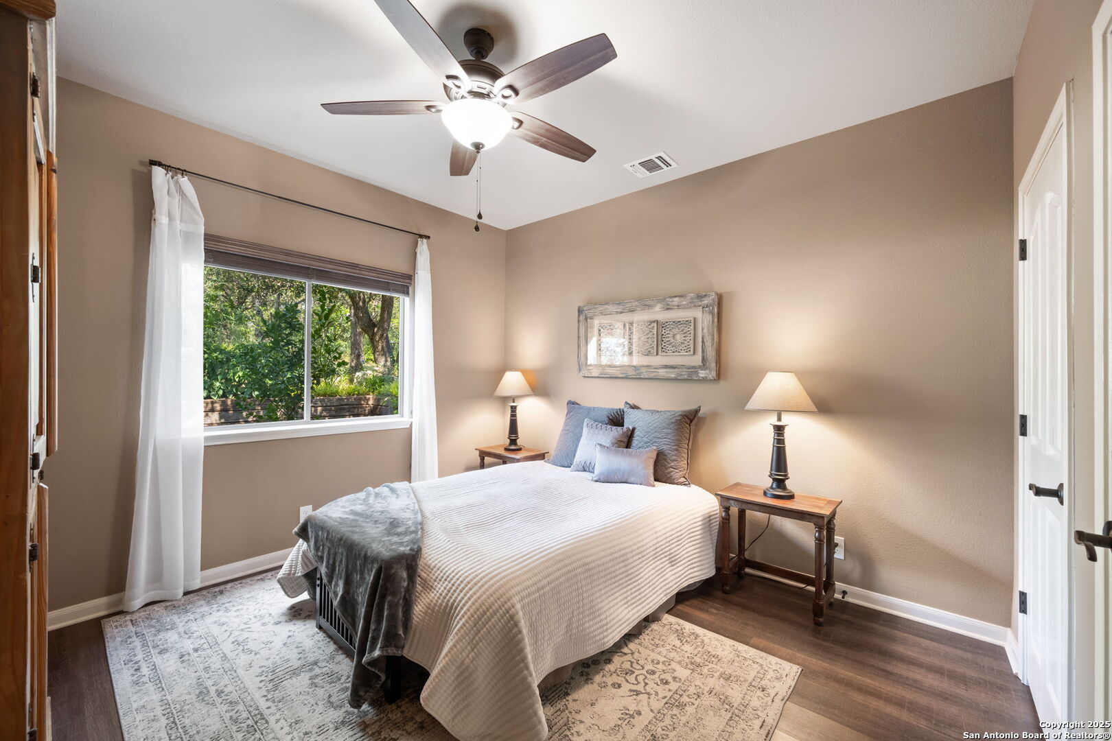 14507 John David Helotes, TX 78023 - Photo 15 of 49 a bedroom with a large bed and a chandelier
