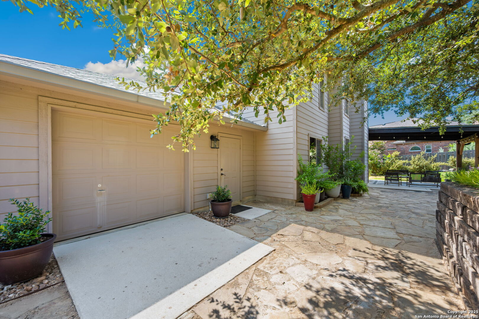14507 John David Helotes, TX 78023 - Photo 21 of 49 a view of a backyard with potted plants and a large tree