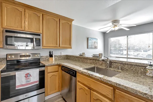 a kitchen with granite countertop a sink appliances cabinets and furniture