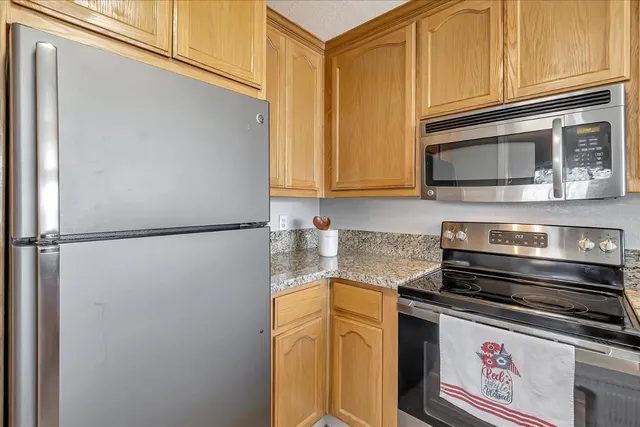a kitchen with stainless steel appliances granite countertop a refrigerator stove and microwave