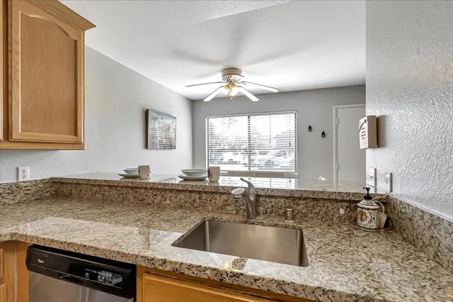 a kitchen with granite countertop a sink a stove and cabinets