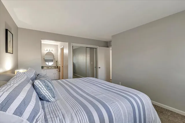 a bedroom with a bed and painting on the wall