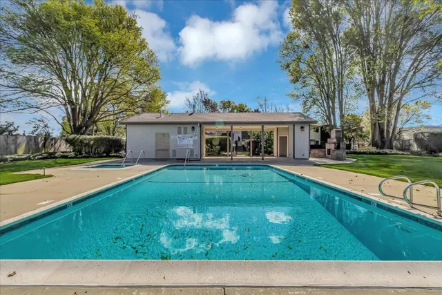 a house view with swimming pool and view of trees