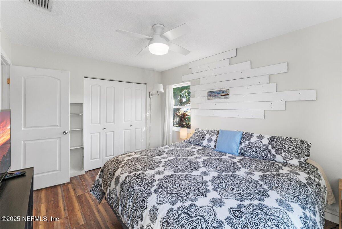 125 Rio Del Mar Street, Unit A St. Augustine, FL 32080 - Photo 15 of 30 a bedroom with a large bed and a chandelier