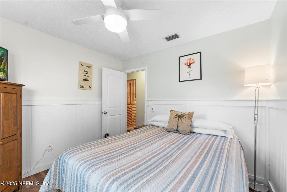 125 Rio Del Mar Street, Unit A St. Augustine, FL 32080 - Photo 16 of 30 a bedroom with a bed and a chandelier