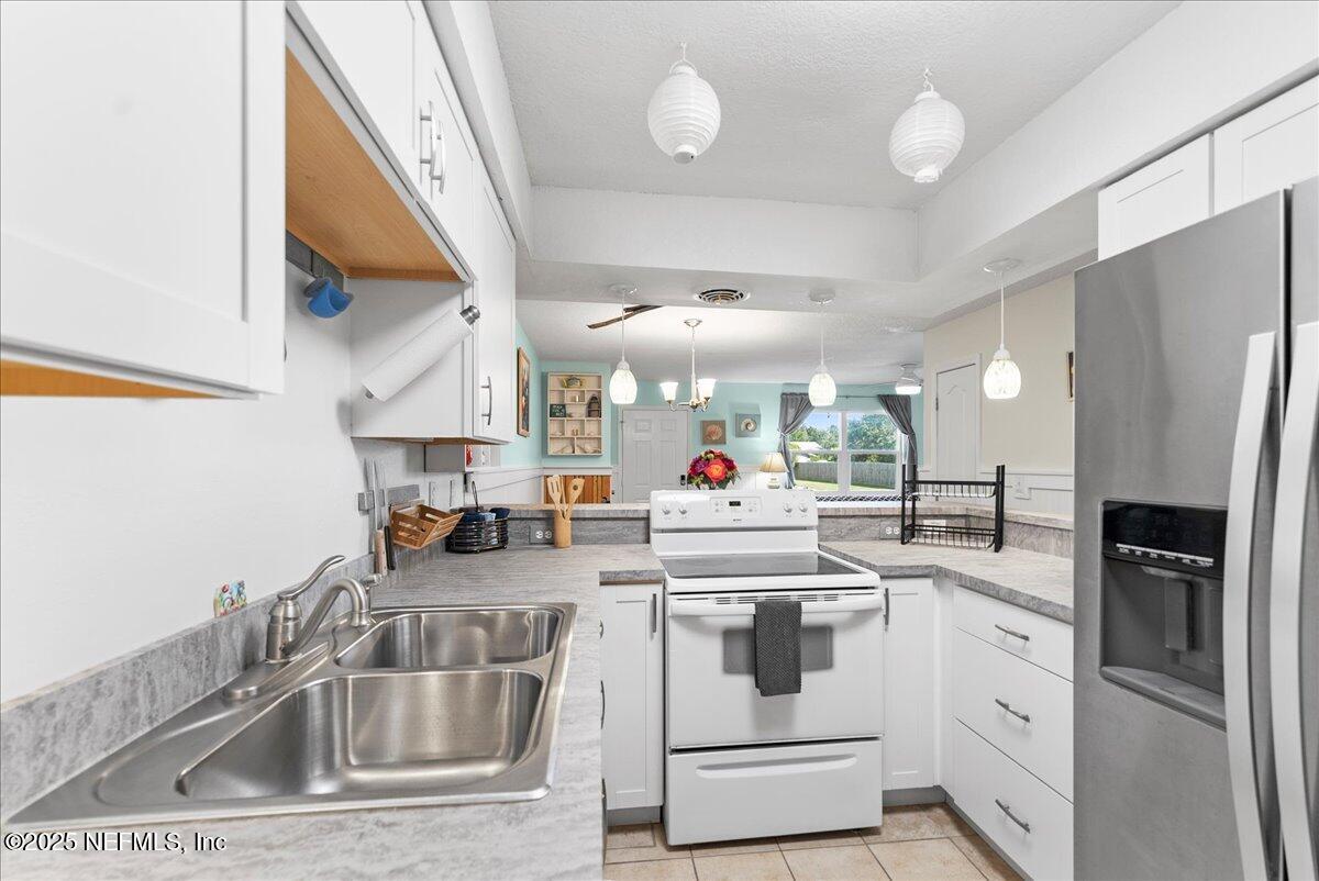 125 Rio Del Mar Street, Unit A St. Augustine, FL 32080 - Photo 7 of 30 a kitchen with white cabinets and stainless steel appliances
