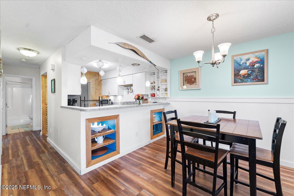 125 Rio Del Mar Street, Unit A St. Augustine, FL 32080 - Photo 8 of 30 a kitchen with stainless steel appliances granite countertop a dining table chairs and a refrigerator