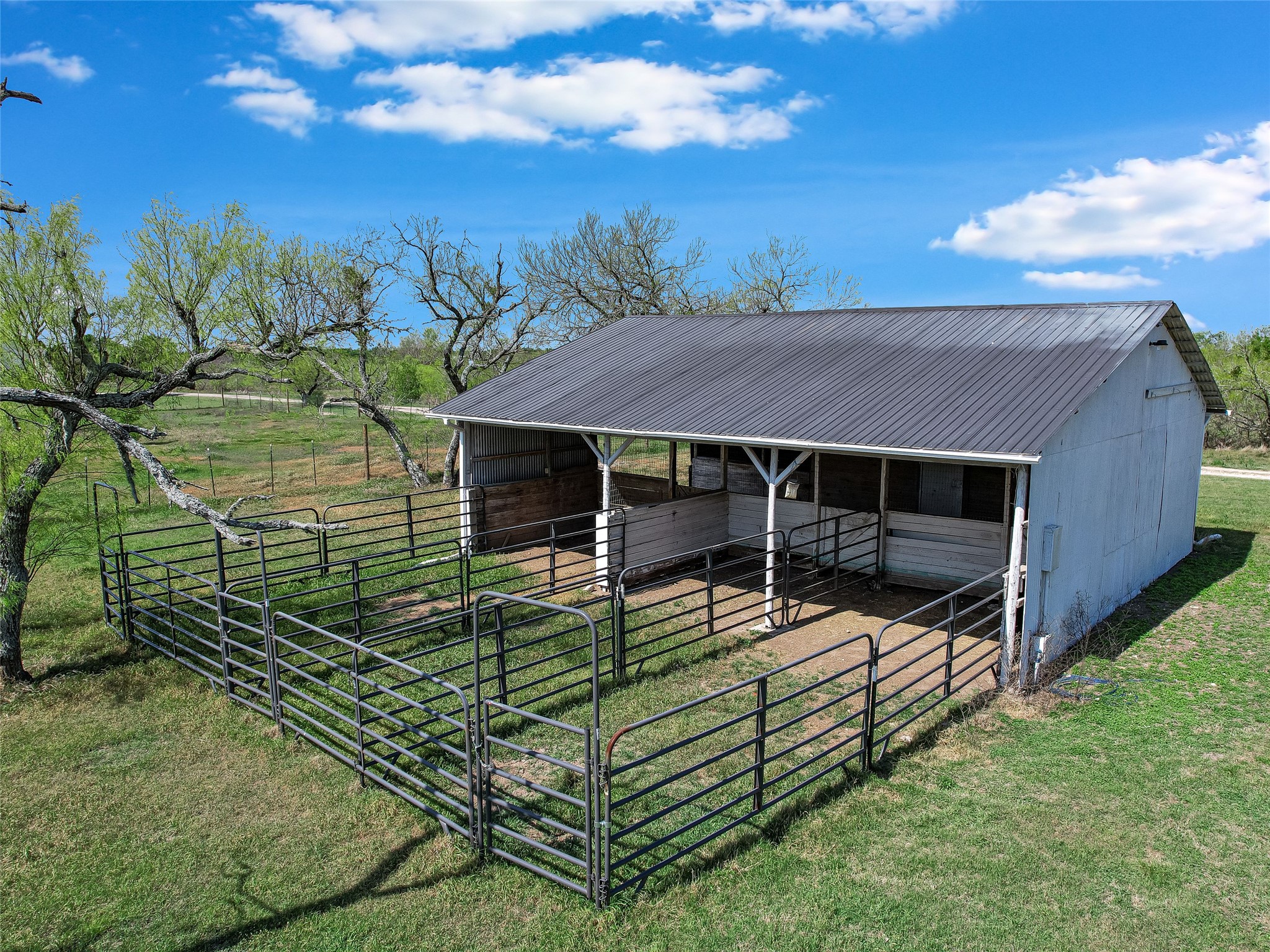 19819 Lockwood Road Manor, TX 78653 - Photo 27 of 29 Ready for animals today, this well-maintained barn with fenced paddocks delivers a turnkey setup for equestrian lovers or those craving a touch of the ranch lifestyle.