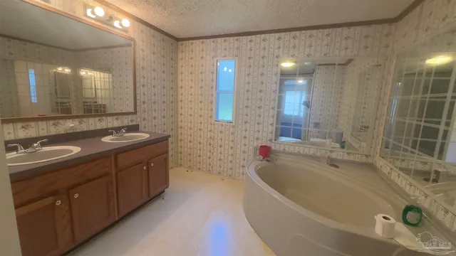 a spacious bathroom with a double vanity sink a large mirror and a bathtub