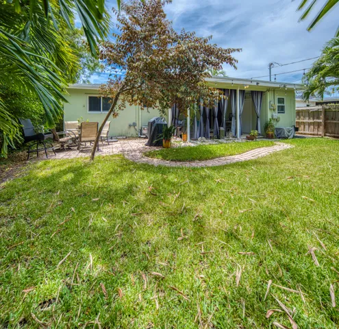a view of a house with backyard and a tree