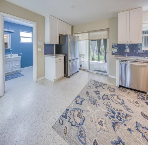a kitchen with a refrigerator sink and cabinets