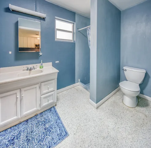 a bathroom with a sink toilet and a mirror
