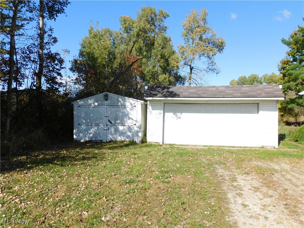5059 Leon Road Andover, OH 44003 - Photo 18 of 18 View of side of home featuring a lawn, a garage, and a storage unit