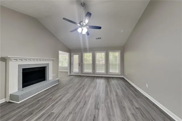 wooden floor fireplace and windows in an empty room