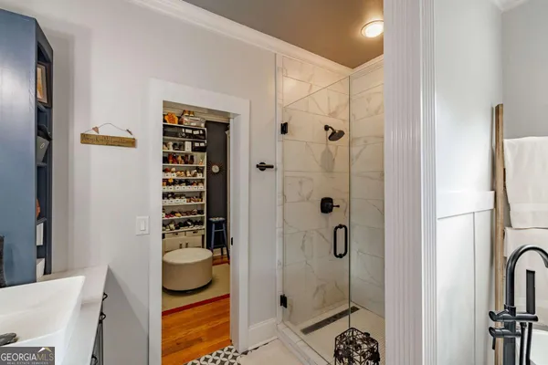 a bedroom with a bed a dresser and a chandelier