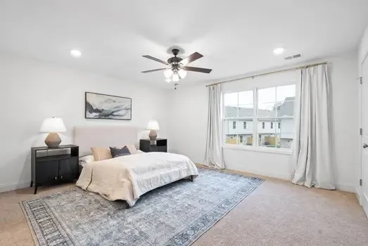 a bedroom with a bed and a ceiling fan