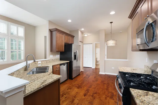 a kitchen with stainless steel appliances granite countertop a sink stove and refrigerator