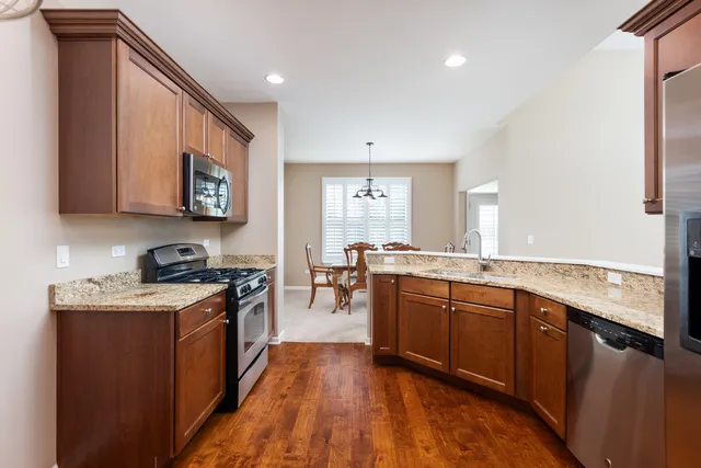 a large kitchen with stainless steel appliances granite countertop a stove and a sink