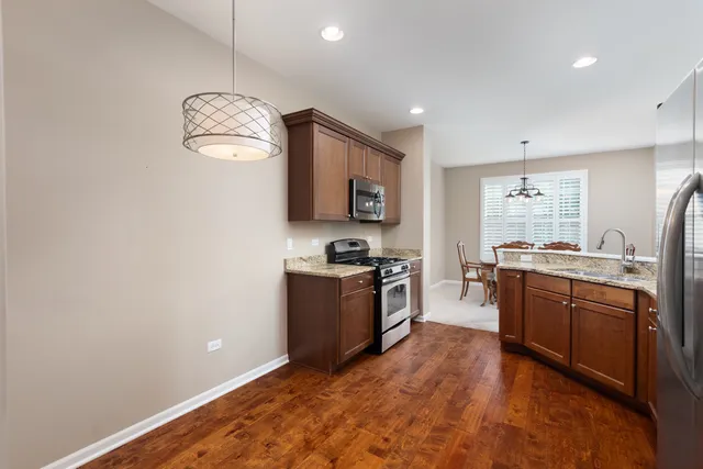 a large kitchen with stainless steel appliances granite countertop a stove and a sink