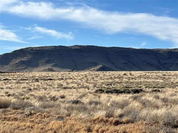 a view of mountain with sunset in background