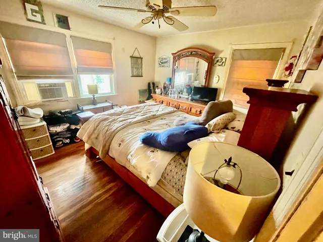 a bedroom with a bed a dresser and window