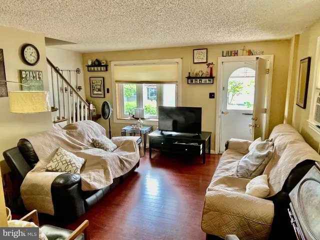a living room with furniture a window and a flat screen tv