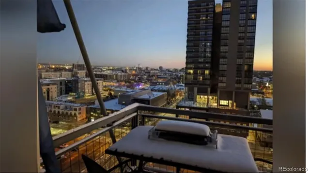 a view of a balcony with chairs and iron stairs