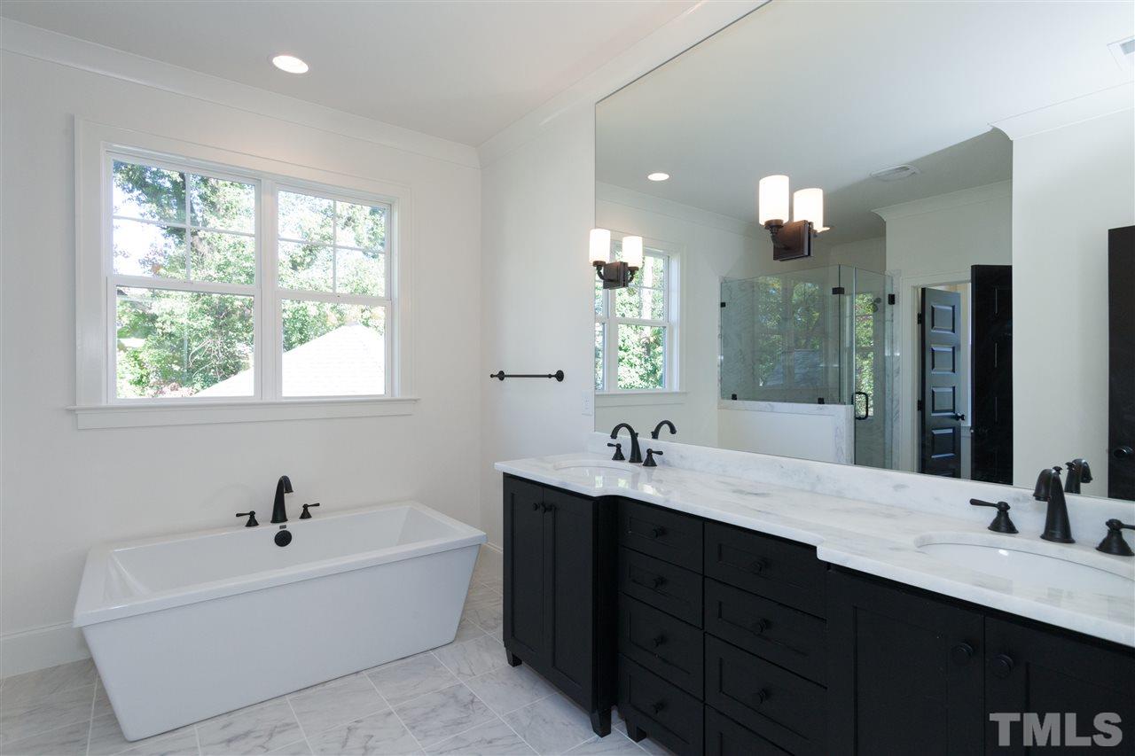 106 Revival Way Raleigh, NC 27608 - Photo 18 of 25 a bathroom with a double vanity sink a mirror and a bathtub