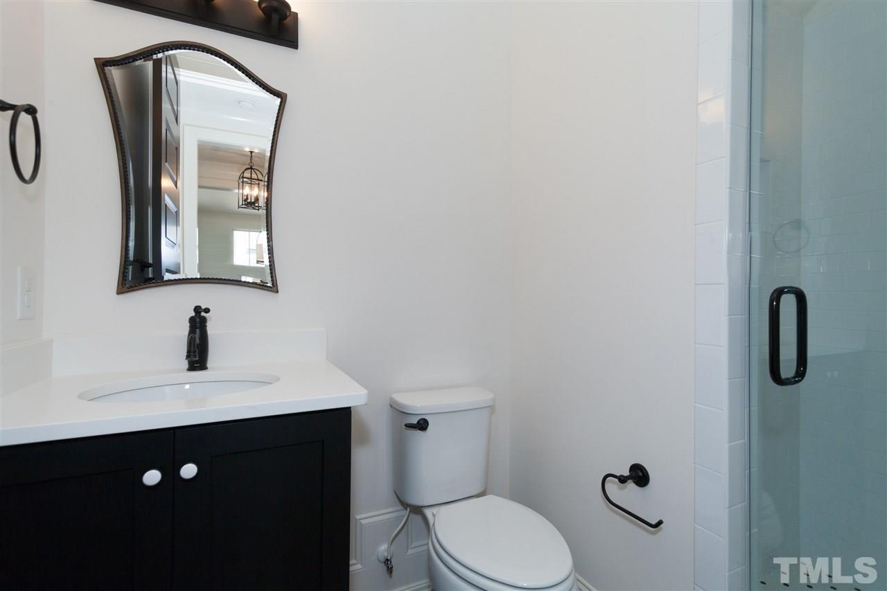 106 Revival Way Raleigh, NC 27608 - Photo 20 of 25 a bathroom with a toilet sink vanity and mirror