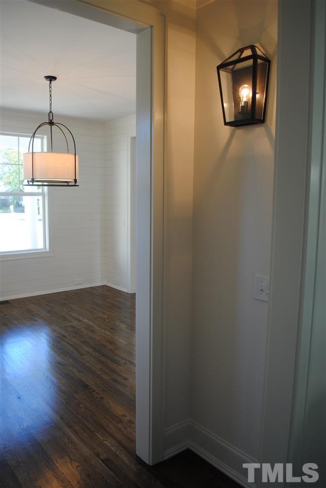 106 Revival Way Raleigh, NC 27608 - Photo 8 of 25 an empty room with wooden floor mirror and windows