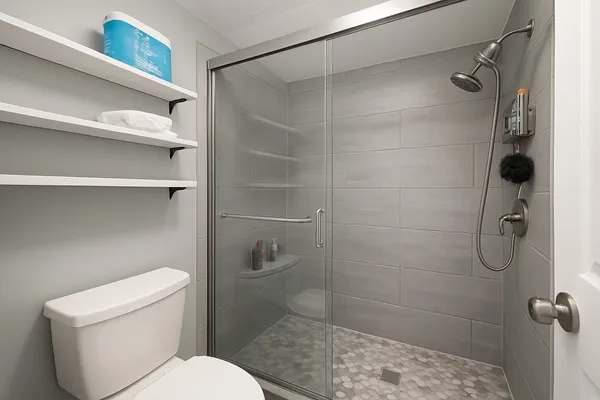 a bathroom with a toilet and a shower