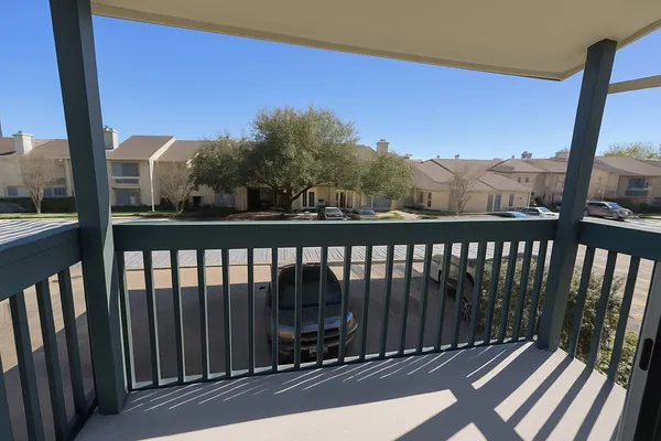 a view of a balcony with wooden floor and fence