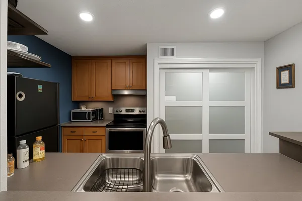 a kitchen with a sink a refrigerator and cabinets