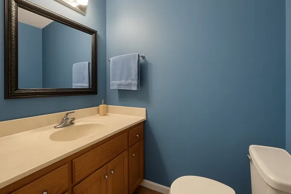 a bathroom with a sink mirror and toilet