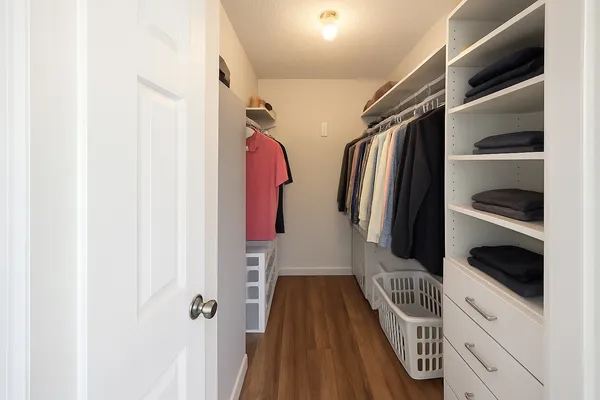 a view of walk in closet with clothes and shoes