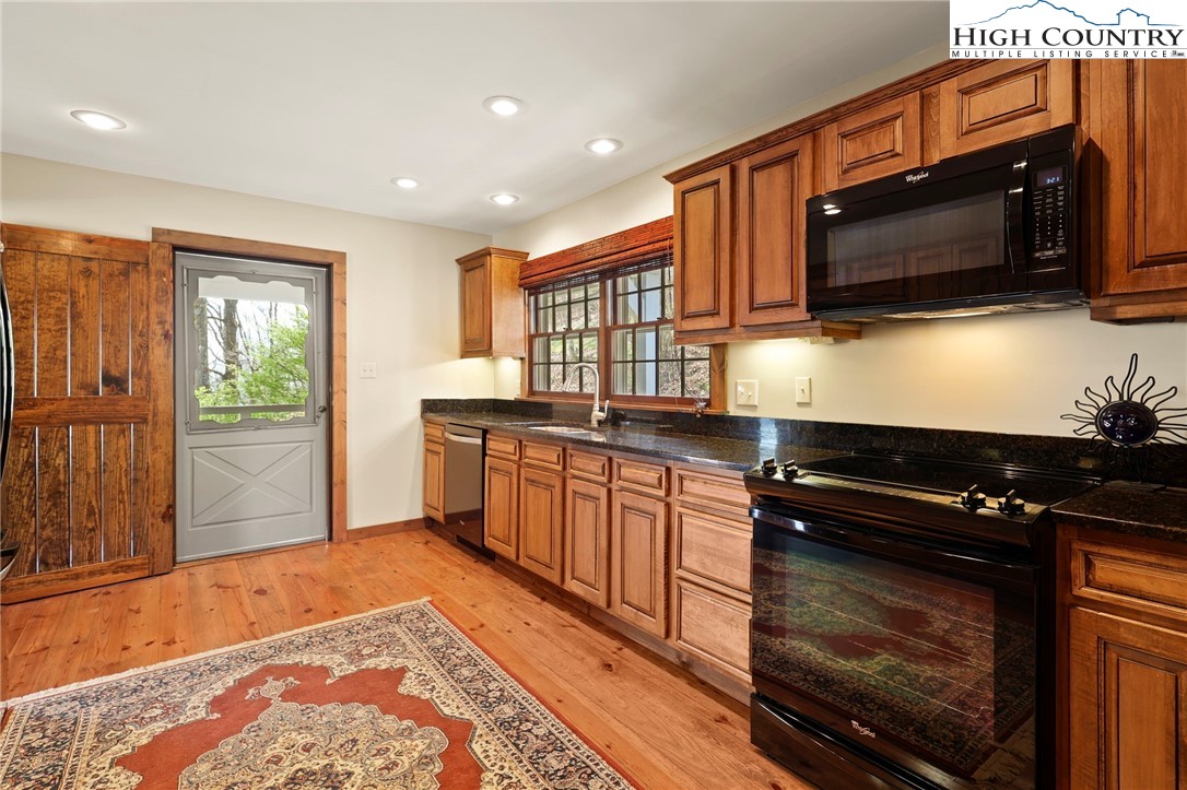 8015 Cloud Forest Lane Blowing Rock, NC 28605 - Photo 12 of 23 a kitchen with stainless steel appliances kitchen island granite countertop a stove a sink and a microwave