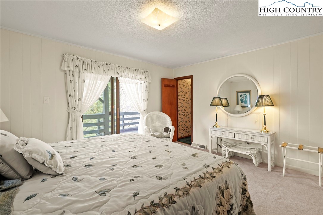 8015 Cloud Forest Lane Blowing Rock, NC 28605 - Photo 20 of 23 a bedroom with a bed and a chandelier