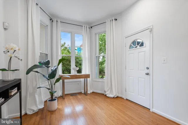 a living room with furniture a mirror and white walls