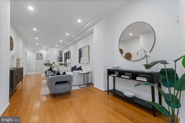 a living room with furniture and a wooden floor