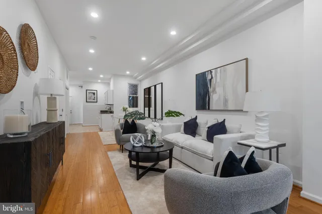 a living room with furniture and a wooden floor