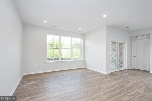 a kitchen with stainless steel appliances granite countertop a sink dishwasher a stove and a refrigerator with wooden floor