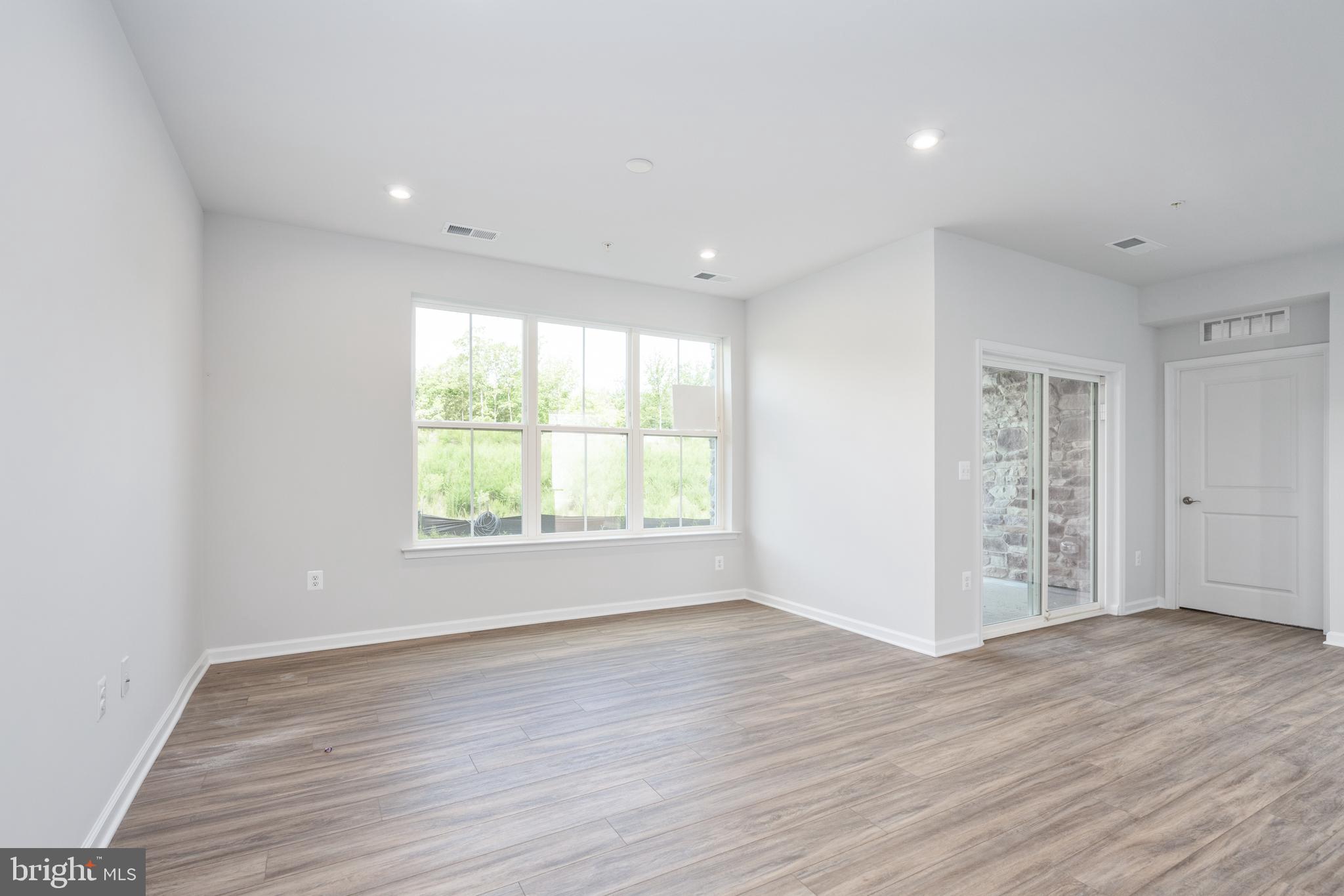 29 Hyssop Way, Unit 103 Stafford, VA 22554 - Photo 11 of 39 an empty room with wooden floor and windows