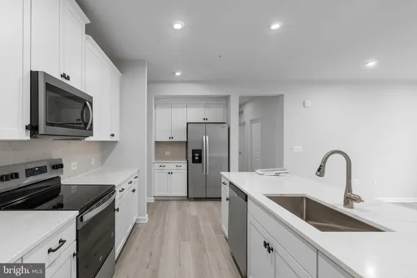 a kitchen with a sink a microwave and cabinets