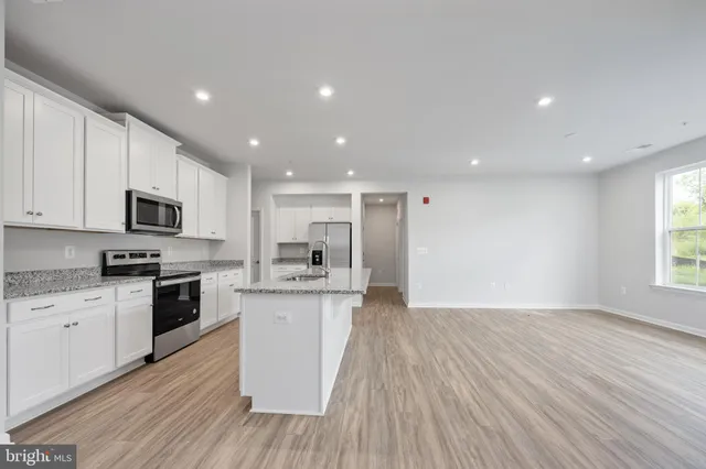 a view of kitchen with kitchen island refrigerator stove microwave and cabinets