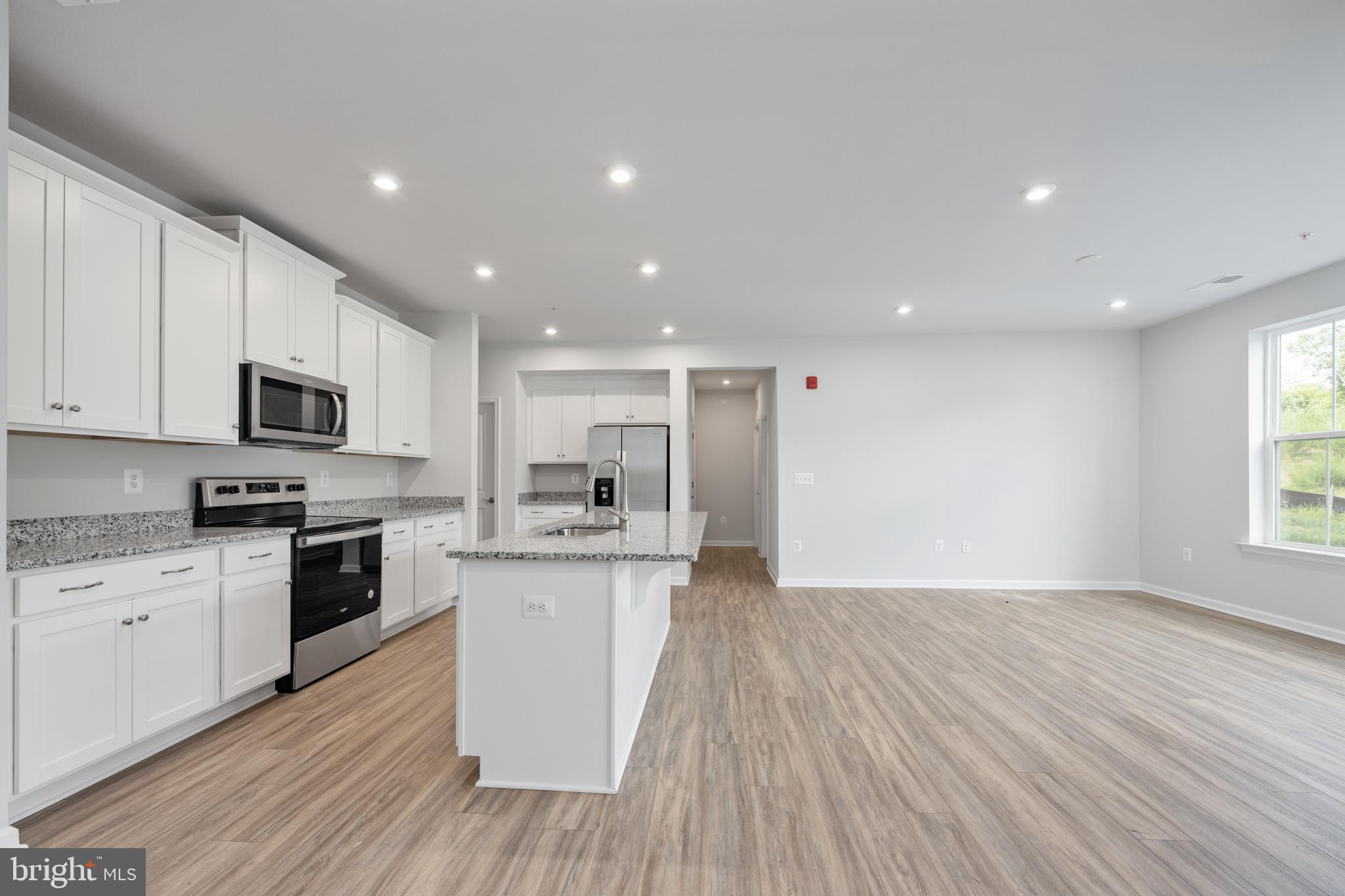 29 Hyssop Way, Unit 103 Stafford, VA 22554 - Photo 16 of 39 a kitchen with stainless steel appliances granite countertop a stove top oven a sink dishwasher and a microwave oven on the wooden floor