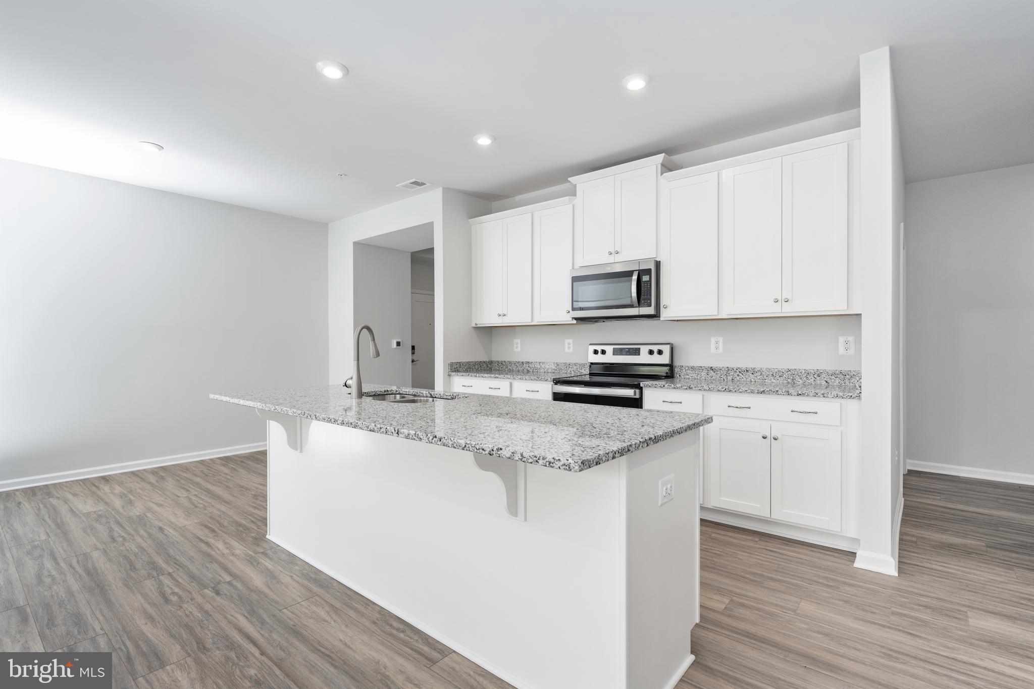29 Hyssop Way, Unit 103 Stafford, VA 22554 - Photo 18 of 39 a kitchen with stainless steel appliances granite countertop a sink a stove a microwave and white cabinets