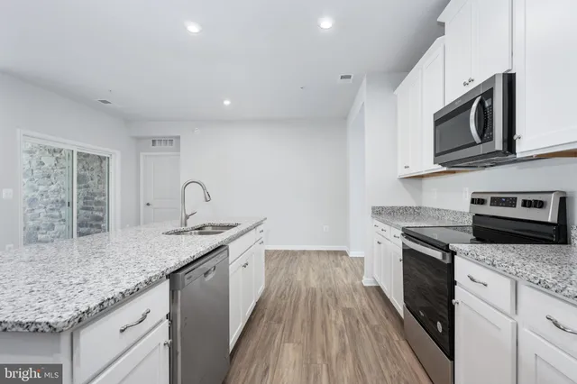 a kitchen with a sink and wooden floor