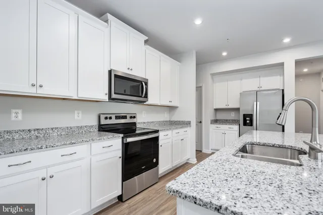 a kitchen with granite countertop a refrigerator and a sink