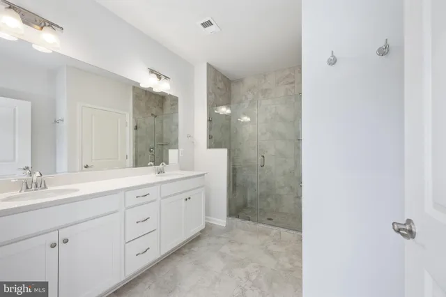 a bathroom with a shower sink and mirror